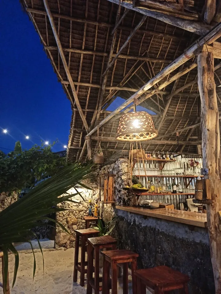 Bar restaurant en plein air avec ambiance chaleureuse et décoration swahilie à Jambiani