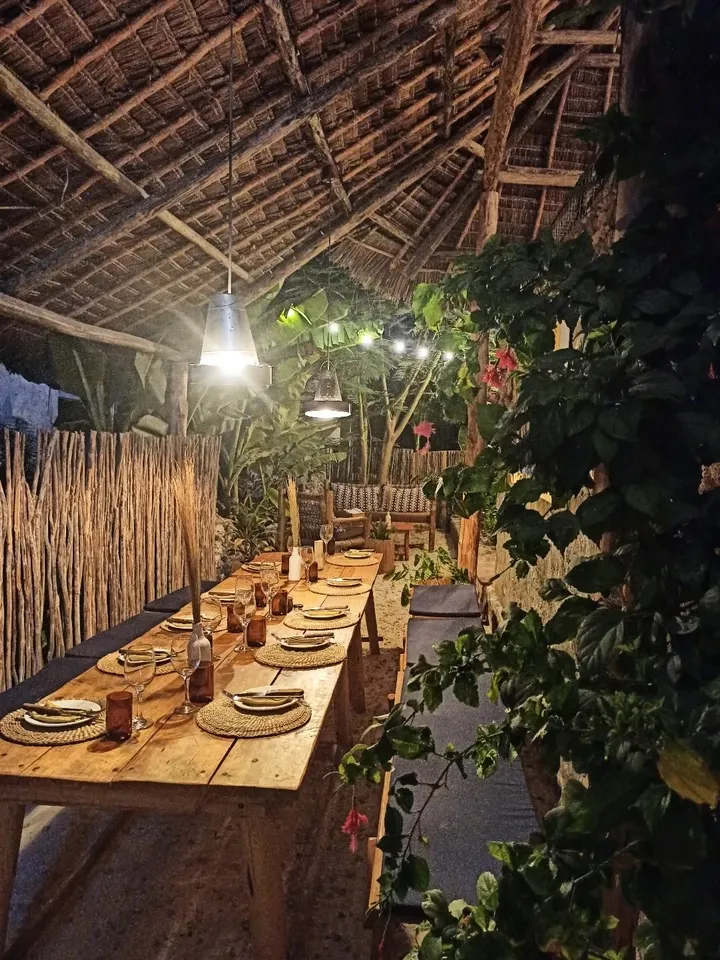Grande table conviviale dans un restaurant tropical éclairé de nuit à Zanzibar